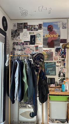 a room filled with lots of clothes hanging on the wall and a desk in front of it