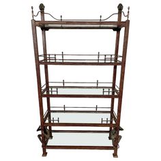 an antique wooden shelf with glass shelves on wheels and metal bars at the top, isolated against a white background