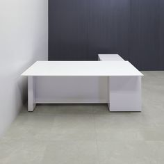 a white table sitting in the middle of a room next to a black and white wall