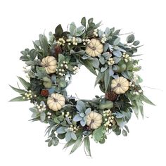 a wreath with white pumpkins and greenery on it is displayed against a white background