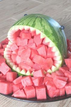 a watermelon and melon cut in half on a plate with other pieces