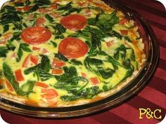 a pizza with tomatoes and spinach on it