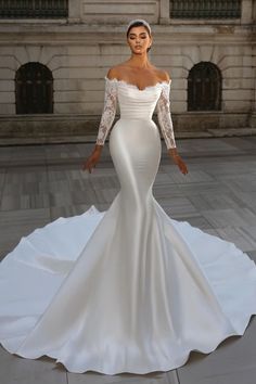 a woman in a white wedding dress posing for the camera with her hands on her hips