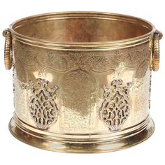 an ornately decorated brass bowl with handles