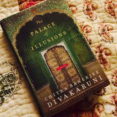 a book sitting on top of a bed next to a quilt covered wallpaper with an ornate doorway