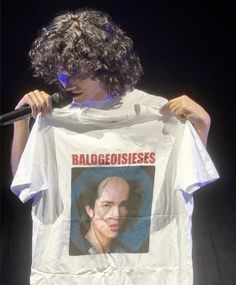 a man holding up a t - shirt with an image of a person on it