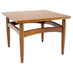 a small wooden table with two legs and a square top on the bottom, against a white background