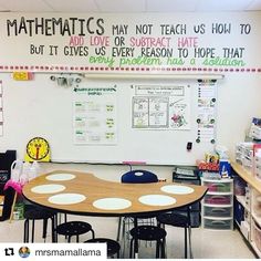 a classroom with lots of desks and writing on the wall above it is a bulletin board