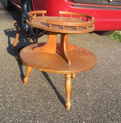 a small wooden table sitting next to a red car