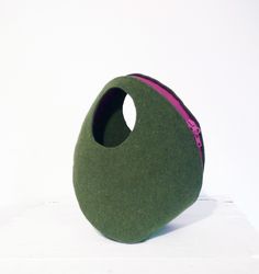 a green and pink object sitting on top of a white surface with a hole in the middle