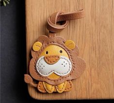 a lion key fobring hanging on a wooden board with a plant in the background