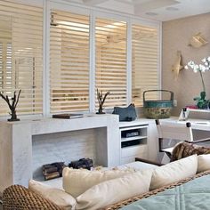 a living room filled with furniture and windows covered in blinds