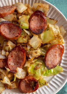 a white plate topped with sausage and cabbage