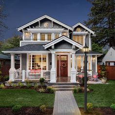 a house that is lit up at night with lights on the front and side windows