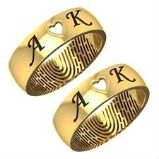 two gold rings with initials and hearts on them