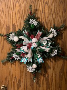 a christmas tree decoration on the door with snowflakes and bells attached to it