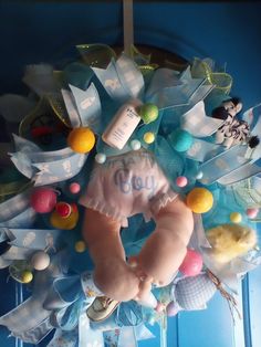 a wreath with baby's clothes and toys on it