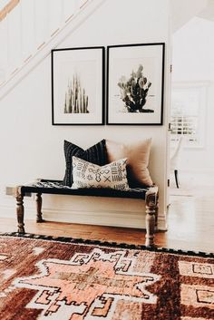 a living room with two pictures on the wall and a bench in front of it