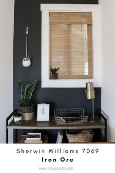 a black and white wall with a window in the corner next to a shelf filled with potted plants