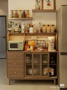 a kitchen area with a microwave, refrigerator and shelves