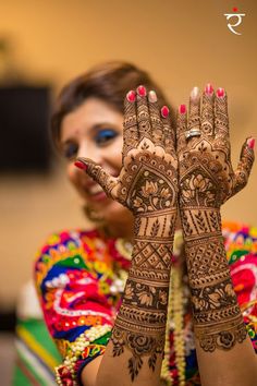 a woman holding her hands up to show the hendi