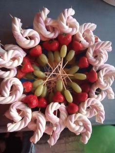 a close up view of some fruit on a stick in the center of a flower arrangement