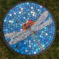 a mosaic tile table with a dragonfly on it