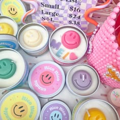 many small containers with smiley faces on them and a pink bag in the middle one