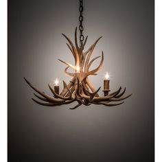 the antler chandelier is made from wood and has three candles in it