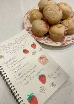 a plate of muffins next to a recipe book