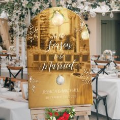 a wooden easel holding a sign that says it's the season to be married