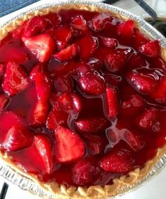 a pie with strawberries on it sitting on top of a table