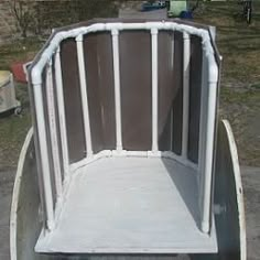 an empty white cart sitting on the side of a road