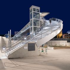 an escalator in front of a building with stairs leading up to the top