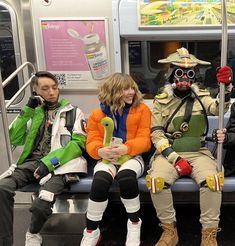 three people in costumes sitting on a subway