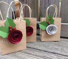 three brown paper bags with holly decorations on them