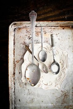 an old metal tray with spoons and ladles