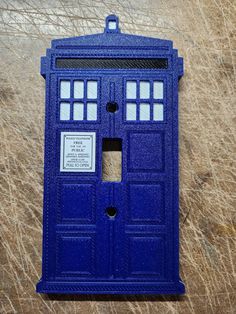 a blue phone booth sitting on top of a field