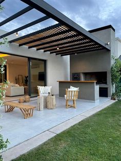 an outdoor living area with patio furniture and grill in the back yard at night time