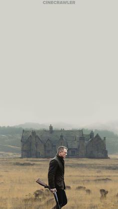 a man walking across a grass covered field