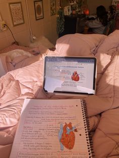 an open notebook sitting on top of a bed