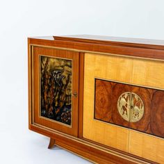 a wooden cabinet with two paintings on the front and side panels inlayed to it