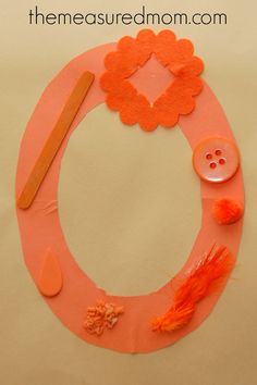 an orange paper plate with buttons and other crafting supplies on it that says, the measured mom