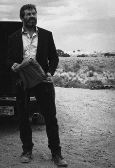 a man standing next to a truck in the desert