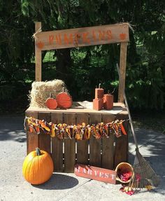 pumpkins and hay are on display at an outdoor market stall with signs that read pumpkin springs