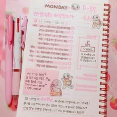 a pink notebook with writing on it next to a pen