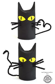 two black cats made out of toilet paper with yellow eyes and whiskers on them