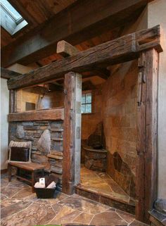 a room with stone floors and wooden beams on the ceiling, along with a fireplace