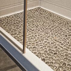 a metal grate sitting on top of a cement floor next to a building wall