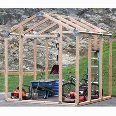 a small shed is being built with tools on the ground and in front of it